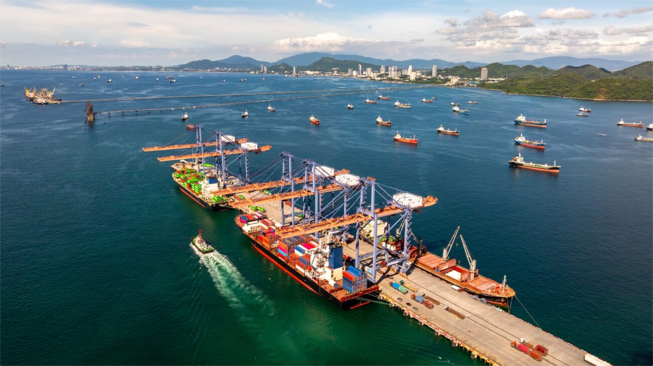 Aerial view of an international container port with vessels at anchor offshore